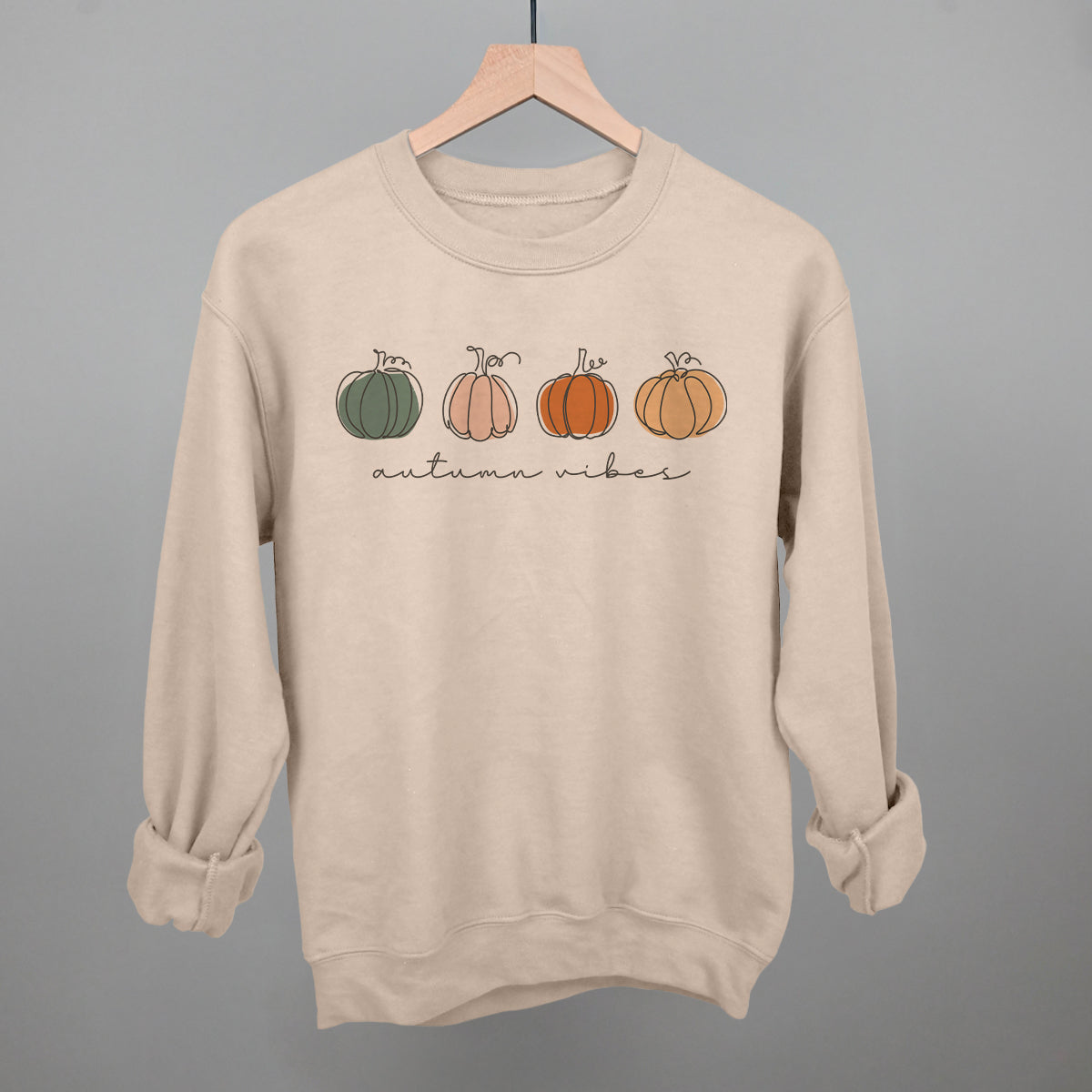 Beige Autumn Pumpkin Doodles sweatshirt with four pumpkins and autumn vibes lettering