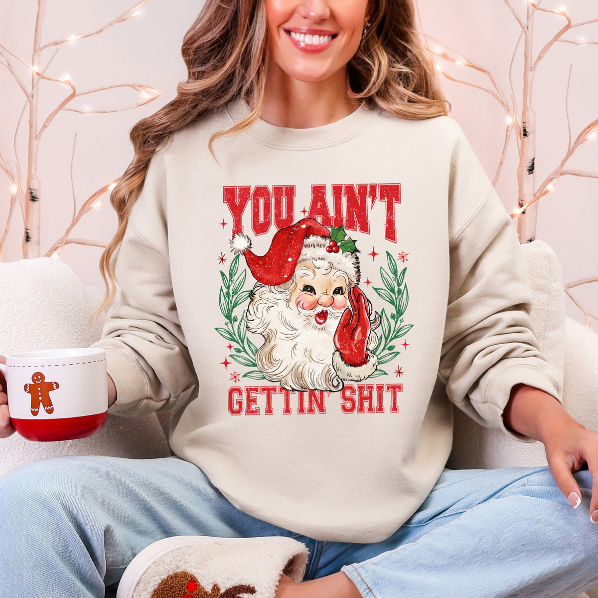 Cream Christmas sweatshirt with a retro Santa and You Ain't Gettin Shit lettering